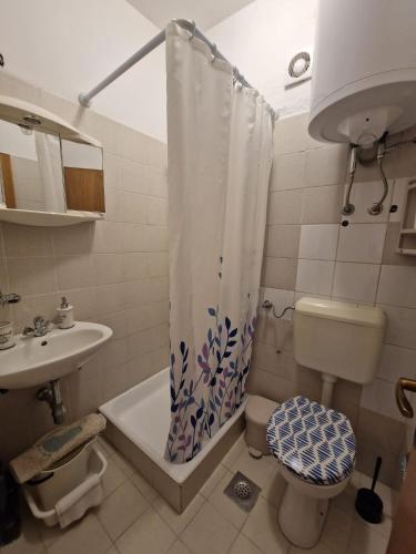 La salle de bains est pourvue d'un lavabo et d'un rideau de douche. dans l'établissement Old town - AP2, à Tribunj