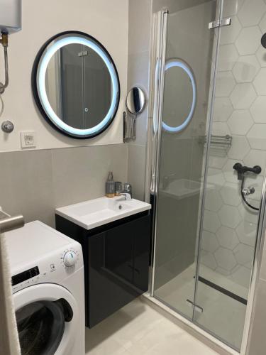 a bathroom with a shower and a washing machine at Vitas Apartments in Zaton