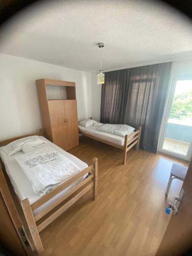 a bedroom with two beds and a large window at Hostel Heimli in Pristina