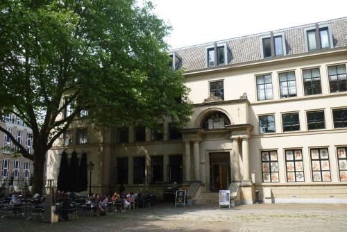 a building with people sitting at tables in front of it at B&B Limes Oudwijk in Utrecht