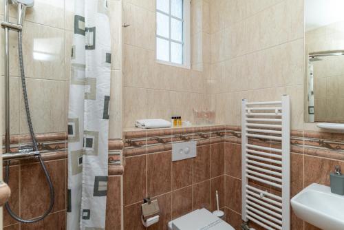a bathroom with a shower and a toilet and a sink at Ornament Hotel in Sarajevo