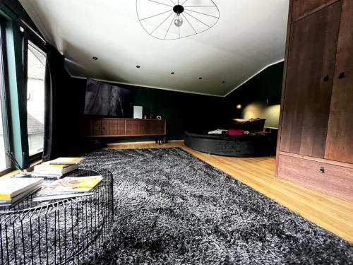 a living room with a large rug and a ceiling at BLACK HOUSE - premium holiday guest house in Priedkalne