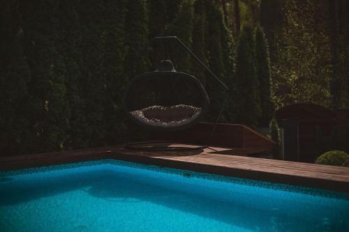 a swimming pool with a chandelier in front at BLACK HOUSE - premium holiday guest house in Priedkalne