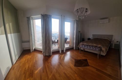 a bedroom with a bed and sliding glass doors at Dernier étage d'une maison in Roquebrune-Cap-Martin