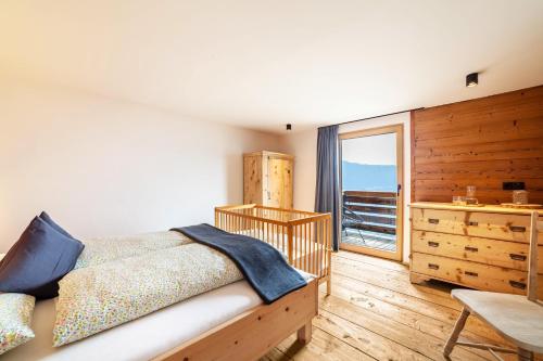 um quarto com uma cama, uma cómoda e uma janela em Ferienhaus Mutlechnerhof em Caines