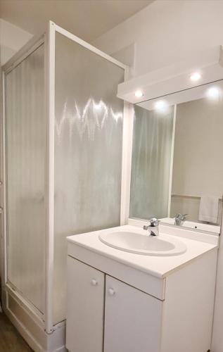 une salle de bain blanche avec un lavabo et un miroir dans l'établissement Ty Noé - Hypercentre - Wifi - Linge fourni, à Vannes