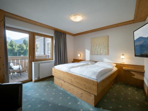 a bedroom with a large bed and a balcony at Gästehaus Gollner in Fieberbrunn