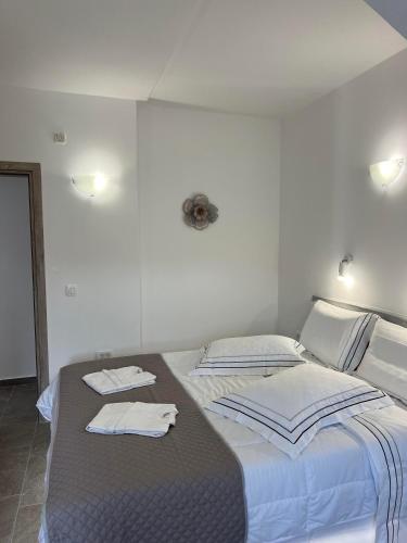 a bedroom with two beds with towels on them at Petit Homme by Andreas in Perissa