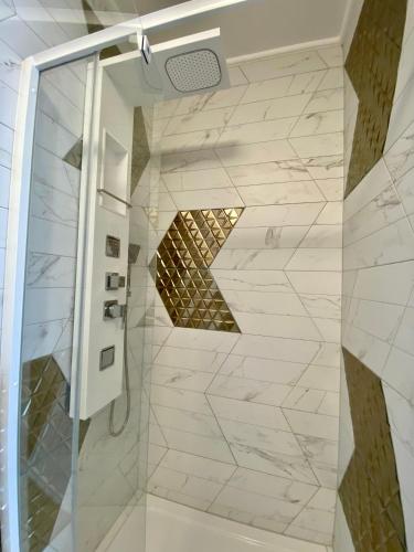 a shower with a glass door in a bathroom at CasaBlanca vendégház in Abádszalók