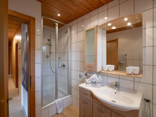 ein Bad mit einem Waschbecken und einer Dusche in der Unterkunft Gästehaus Gollner in Fieberbrunn