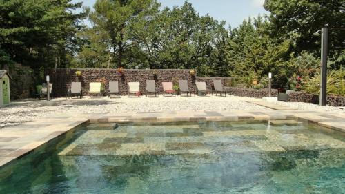 une piscine dans une cour avec des chaises autour dans l'établissement La Grange à Marjo, à Faucon