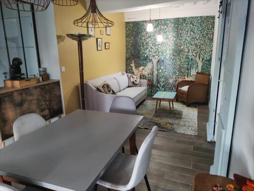 un salon avec une table, des chaises et un canapé dans l'établissement Chez Nick et Martine suite privative, à Palinges