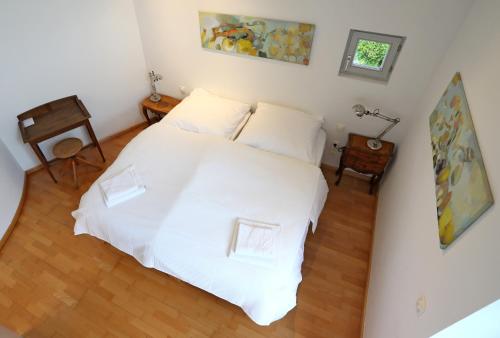 1 dormitorio con 1 cama blanca y 2 almohadas blancas en 25 Min to the Center - 220 m2 Artist's House South of Munich - for Vacation or Great Workshops, en Oberhaching