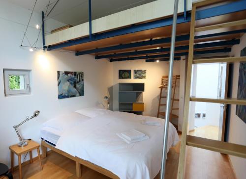 - une chambre avec un lit et une mezzanine dans l'établissement 25 Min to the Center - 220 m2 Artist's House South of Munich - for Vacation or Great Workshops, à Oberhaching