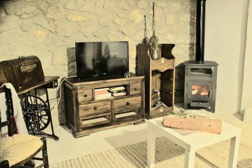 - un salon avec une télévision et un poêle à bois dans l'établissement Mirador de Mijares, à Los Pertegaces