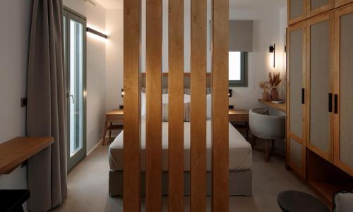 ナクソス・コラにあるMakava Suites Naxosのベッドルーム1室(ベッド1台、デスク、バスルーム付)