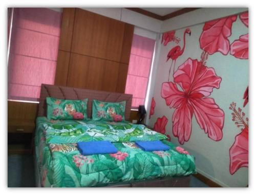 1 dormitorio con 1 cama con flores en la pared en ศูนย์ฝึกอบรมสวนสัตว์เปิดเขาเขียว JJJ, 