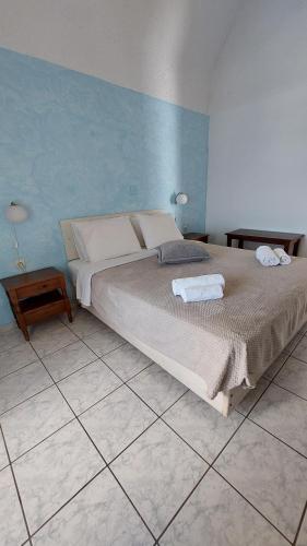 a bedroom with a bed with two towels on it at Olympic Villas in Oia