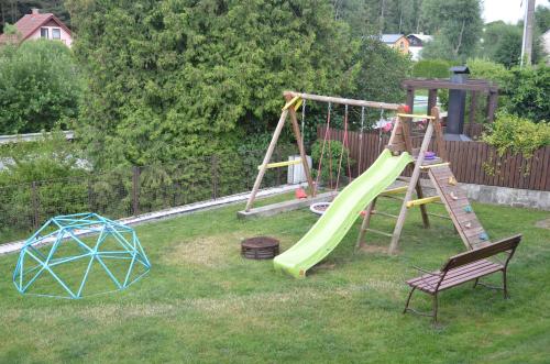 a yard with a playground with a slide and a chair at Chalupa v Moravském krasu v obci Lipovec in Lipovec