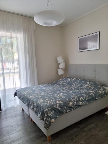 1 dormitorio con 1 cama grande con manta azul en Aisa Holiday Apartment, en Pärnu