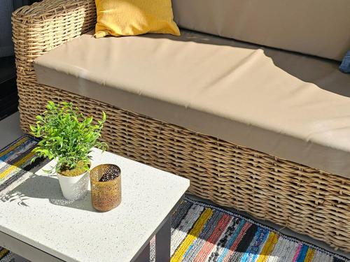 a couch and a table with a plant on it at Ellipse Waterfall Luxury Apartments in Midrand