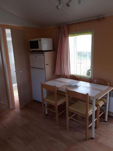 a kitchen with a table and chairs and a microwave at Numéro 50 in Saint-Martin-Plage