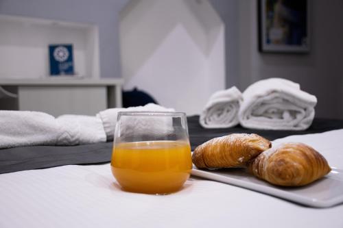a glass of orange juice and croissants on a table at Megaris Luxury Suite Rooms in Naples