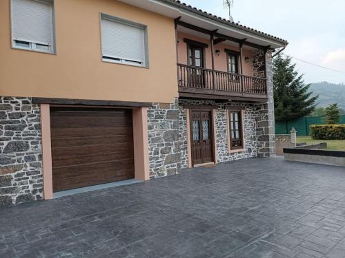 uma casa com uma entrada de pedra em frente em Casa rural en Sariego em Villar