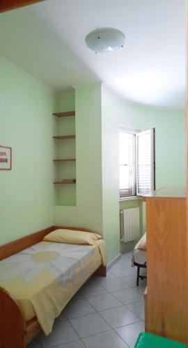 ローディ・ガルガーニコにあるCasa Ameliaの緑の壁のベッドルーム1室(ベッド1台付)