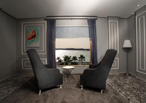 a living room with two chairs and a window at Golden Garden Al Corniche in Dammam