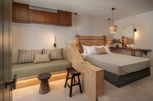 Un dormitorio con 2 camas y un taburete. en Makava Suites Naxos en Naxos