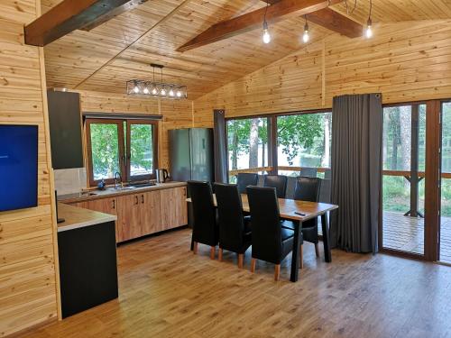 eine Küche und ein Esszimmer mit einem Tisch und Stühlen in der Unterkunft Osrodek Wypoczynkowy RAJ in Mostowo