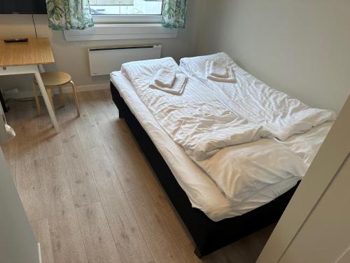 an unmade bed in a small room with a window at Åndalsnes Sentrum 1-roms Apartment in Åndalsnes
