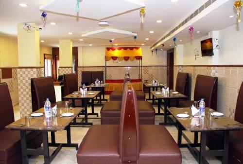 a dining room with tables and chairs in a restaurant at SET Residency in Kumbakonam