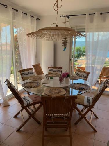 une salle à manger avec une table, des chaises et un lustre dans l'établissement MIKA DE MACHJA, à Propriano