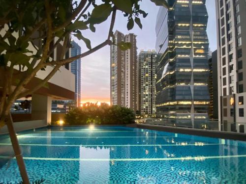 a swimming pool on the roof of a building with a city skyline at Sentral Suites By RKD HOME in Kuala Lumpur