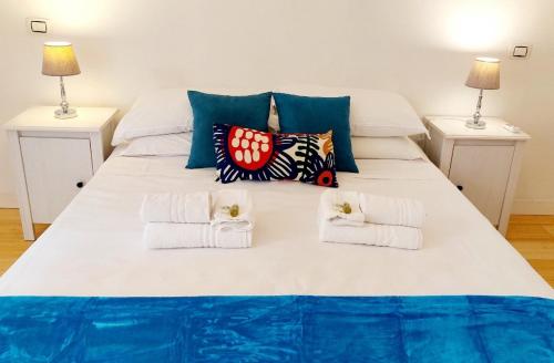 ein großes weißes Bett mit Handtüchern und 2 Lampen in der Unterkunft BBHOME Comfort apartment near Colosseum in Rom