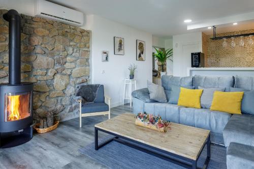 a living room with a blue couch and a fireplace at Casa Rural la Goleta II in San Martín de Valdeiglesias