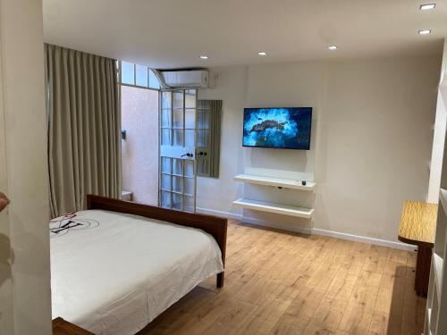 a bedroom with a bed and a tv on the wall at Studio near the sea in Netanya