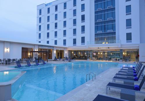 a hotel swimming pool with chairs and a building at Crowne Plaza Airport, an IHG Hotel in Tocumen