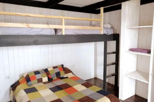 a bedroom with a bunk bed with a quilt at El Racó - Kitesurf Sirena - Cabaña frente al mar in Curanipe