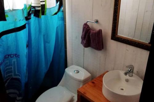 y baño con aseo, lavabo y ducha. en El Racó - Kitesurf Sirena - Cabaña frente al mar, en Curanipe