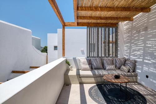 a balcony with a couch and a table at Clementina Paros in Naousa