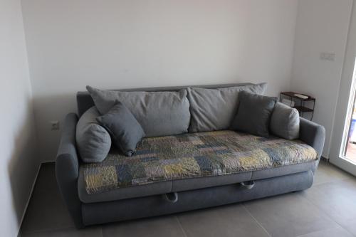 - un canapé gris dans le salon doté d'une fenêtre dans l'établissement Nasedli kit 3 - "Beached whale 3", à Ražanac