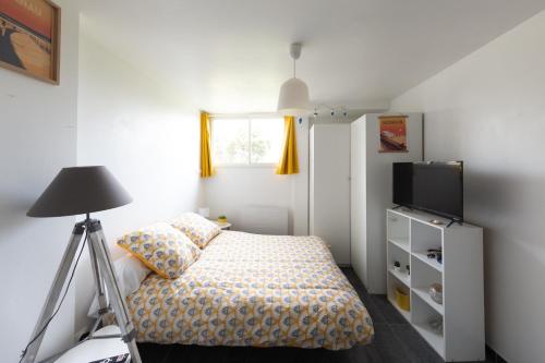 une petite chambre avec un lit et une télévision dans l'établissement Dune Front Paradise - Appartement sur la dune, à Soorts-Hossegor