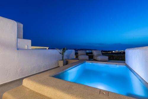 a swimming pool in a house with blue lighting at Sersi Paros Villas & Suites in Kampos Paros