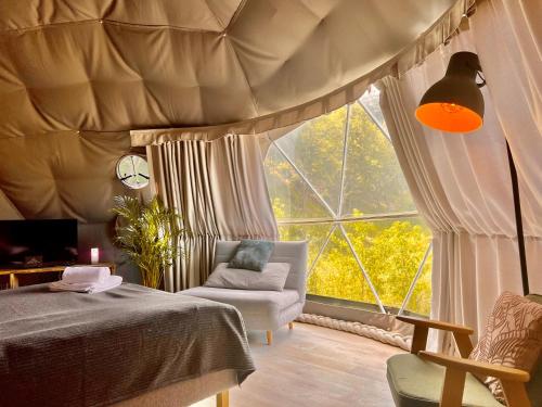 een slaapkamer met een bed en een groot raam bij Na Skraju Lasu Domek na Drzewie & Glamping in Kazimierz Dolny