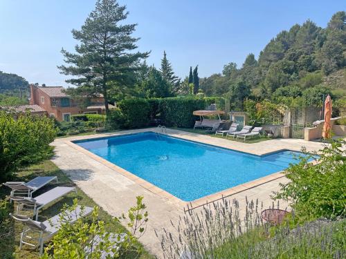 - une piscine dans une cour avec des chaises et des arbres dans l'établissement Mas de Peyre, à Le Beaucet