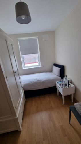 um pequeno quarto com uma cama e uma janela em City Nest. em Dublin