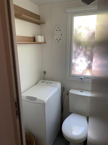 a small bathroom with a toilet and a window at mobilhome la palmyre bonne anse plage in Les Mathes
